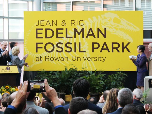 yellow sign unveiled for the Jean & Ric Edelman Fossil Park, as people clap