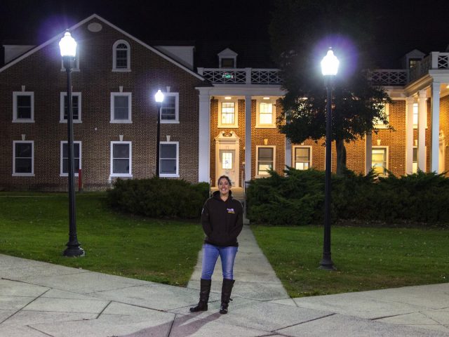 Student stands in front of dorms