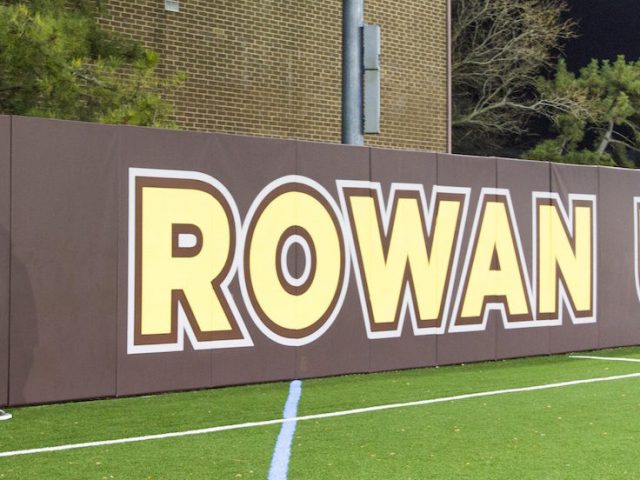 student stands on intramural field