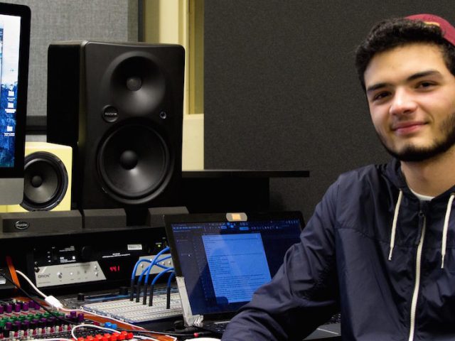 student sits at soundboard