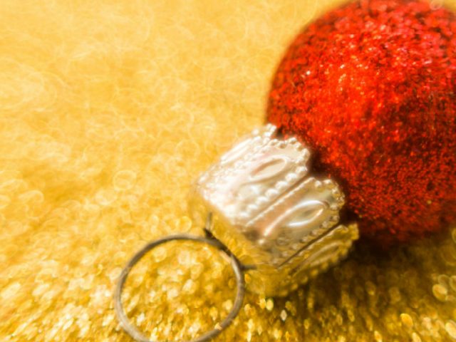 red Christmas ball against a gold background