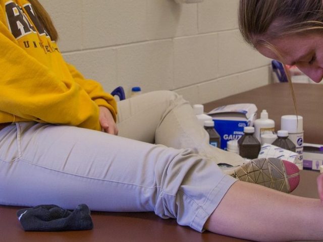 athletic training major works on a student's ankle