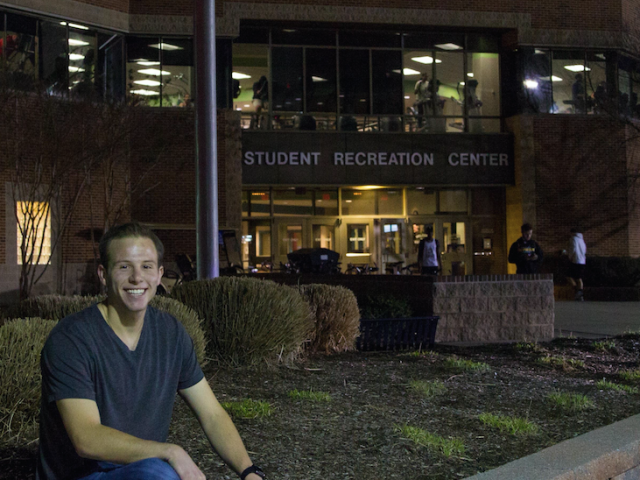 student sits outside rec center