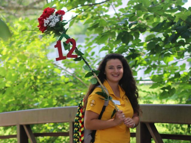 standing on bridge holding 12 sign