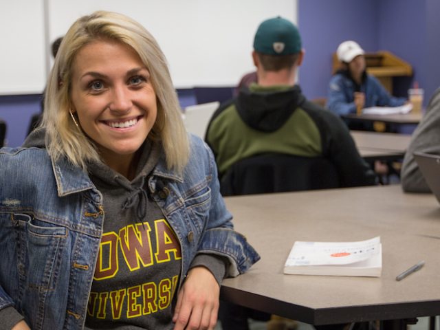 vanessa sitting in a college of communication and creative arts classroom