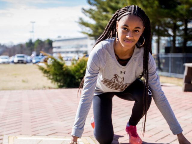 Sidney in track pose outside the track field at Rowan