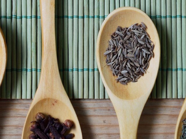 four wooden spoons hold spices