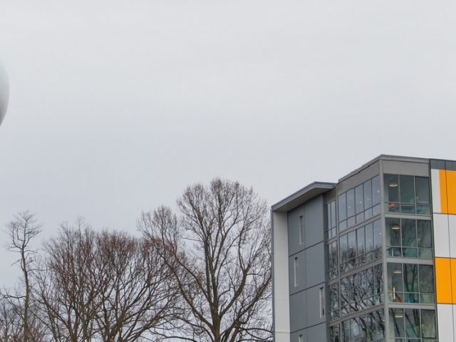 orange gray and white Holly Pointe Commons at Rowan University with Glassboro water tower in view