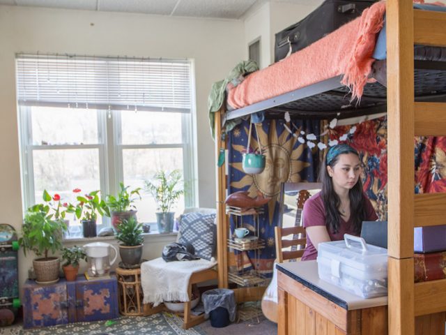 Noel sits at desk in her room in Willow Hall at Rowan University