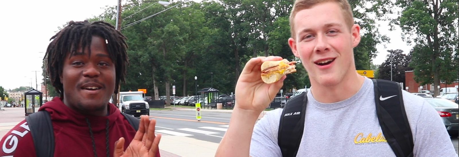 Two Rowan University Students eating a pork roll sandwich