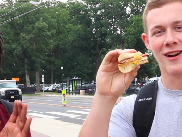 Two Rowan University Students eating a pork roll sandwich