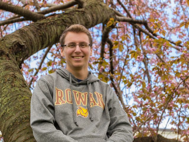 Rowan Alum Scott Timko in a tree with pink flowers