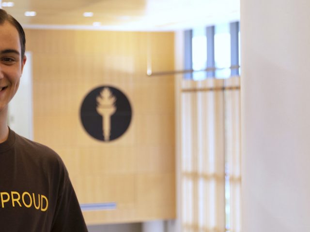 Dan Ryan wearing a #RowanProud shirt standing upstairs at business hall