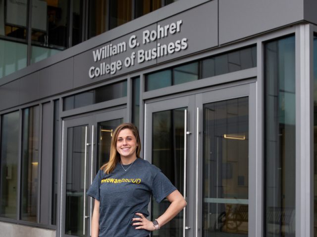 Rachel outside business building with silver sign in background saying Rohrer College of Business