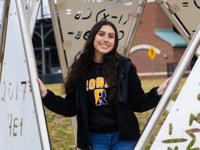 Marcella stands by a metal sculpture outside the Engineering Hall at Rowan University.