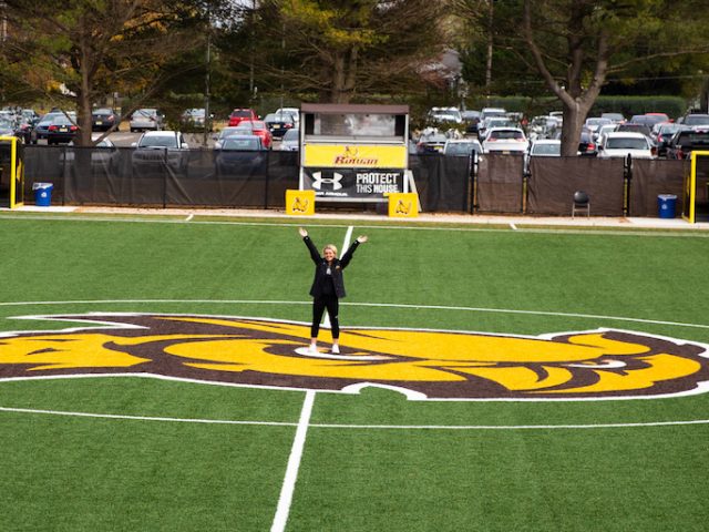 Kylie standing on soccer field, picture taken from bleachers