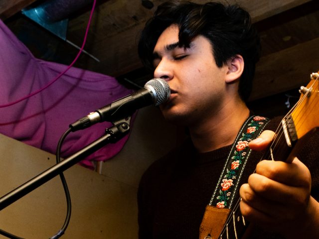 Enzo, Rowan student, playing guitar at a show near Rowan