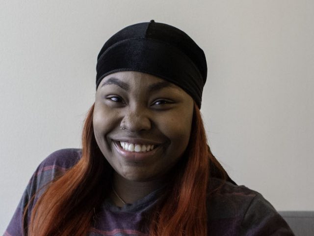 Jakira smiles in front of a white backdrop