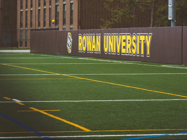 Rowan University sign showing on the athletics field