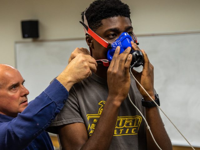 Michael inside training facility with face mask on treadmill