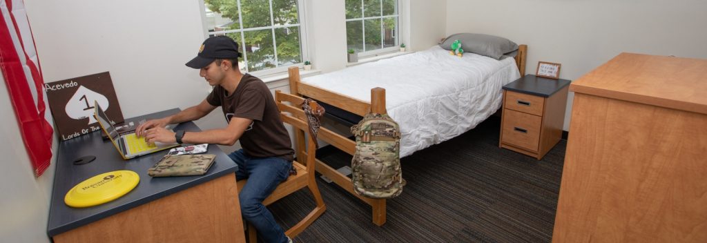 A resident of the Townhouses does homework in his room.