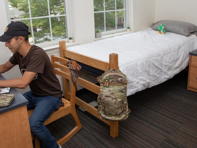 A resident of the Townhouses does homework in his room.