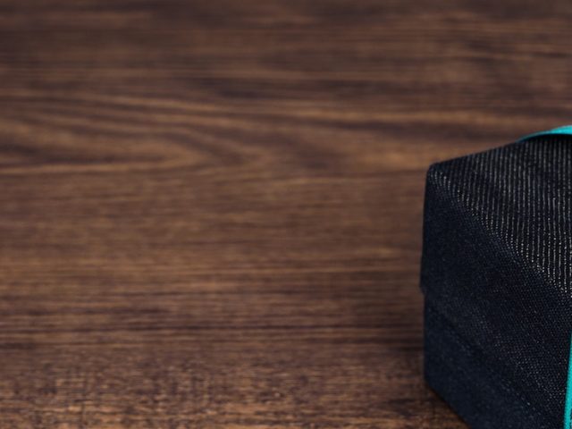 A blue and black present sitting on a wooden table