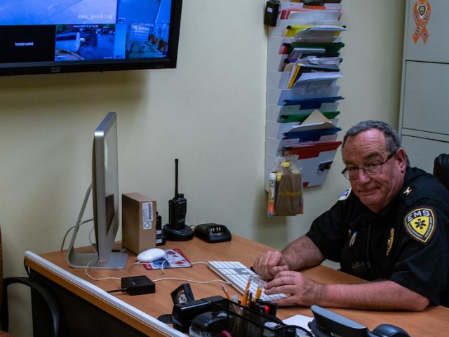 Rowan EMS employee sitting at his desk working diligently on a Mac computer