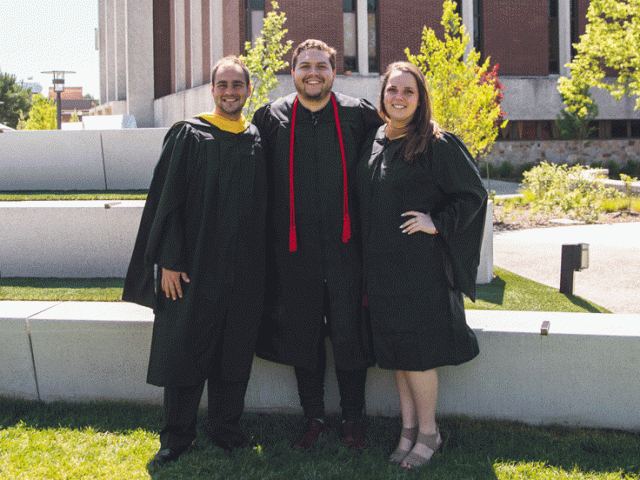 Three Rowan graduates standing together outside Robinson Hall