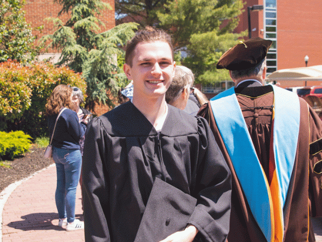 Rowan graduate standing outside after commencement