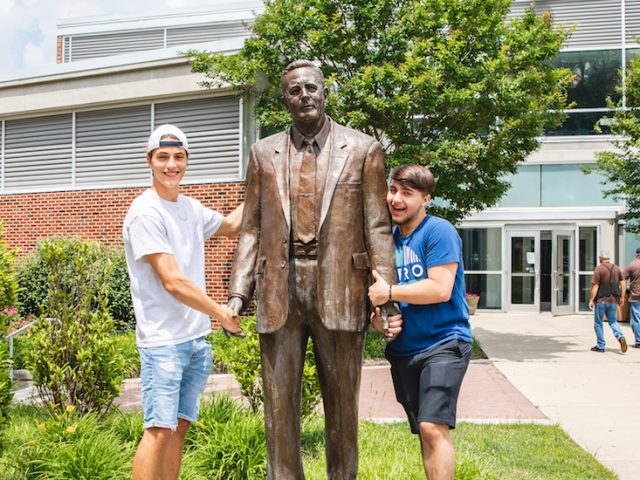 Dillon Weigand and Chase Weigand, new freshmen at Rowan University, pose in a silly way with the Henry Rowan statue