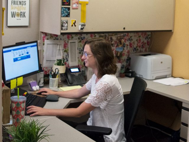 Rowan admissions officer Amanda Kuster working at her desk in Savitz Hall