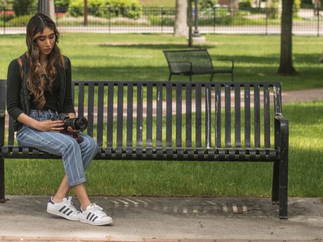 Iridian Gonzalez sits on a bench outside of Bunce Hall