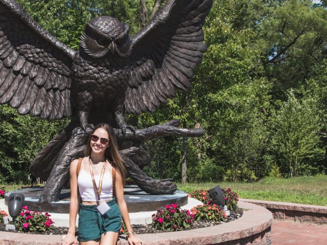 Ariana poses in front of the Rowan Owl statue.