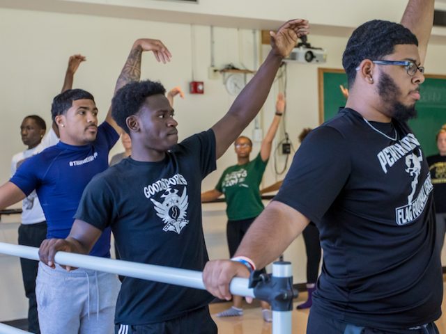 Three students by the ballet bar in a session of Elements of Dance