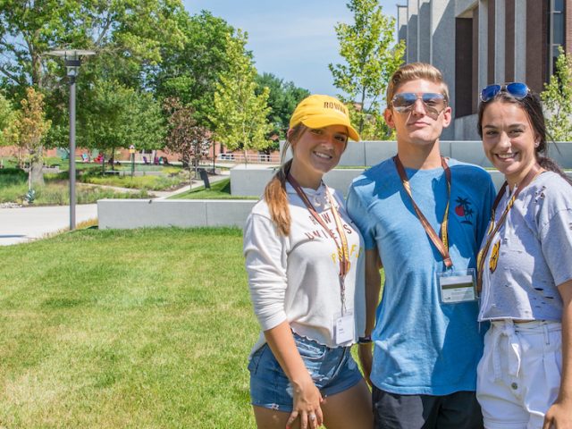 A group photo of three freshmen outside Wilson Hall