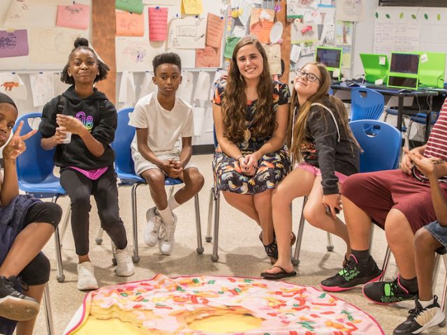 Kasey DiSessa of Rowan University sits in the middle of a row of middle school students she teaches