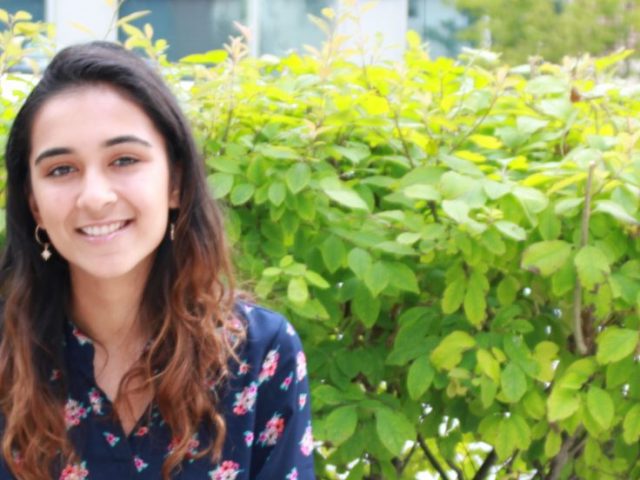 Molecular and cellular biology major Amaal Khan sits outside on a bench