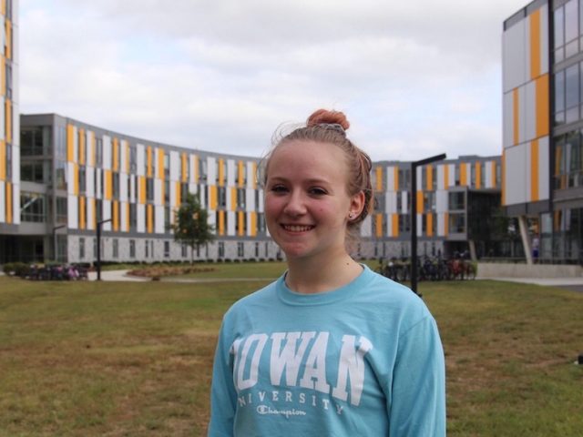 Elizabeth Hudak stands in front of Holly Pointe Commons at Rowan University with the building behind her