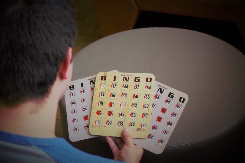 RAH Program Coordinator Joseph Scafiro holds bingo cards, one of the activities offered at Rowan After Hours