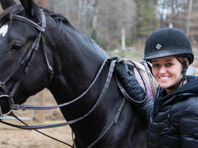 Destiny standing with her horse at the barn