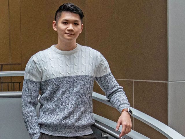 Thai Nghiem stands on the steps inside the Engineering Hall lobby