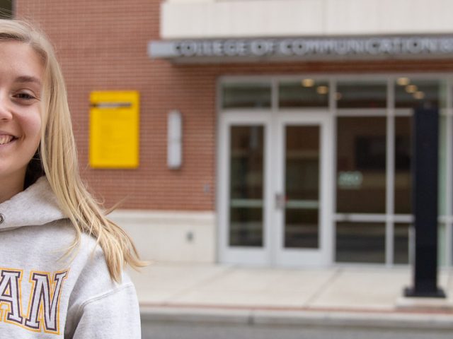 Communication Studies major Ashley Davis stands in front of Victoria Hall