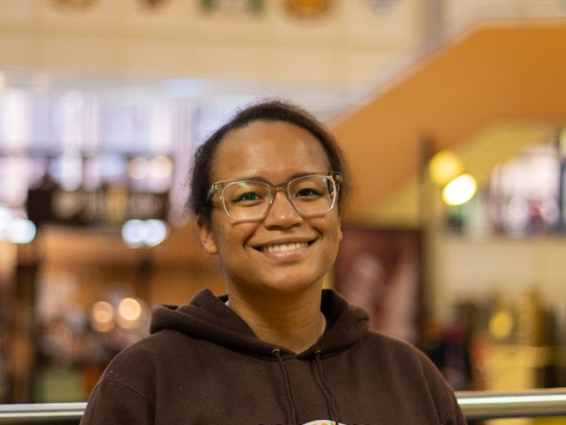 Autumn smiles at the camera for a portrait taken in the student center.