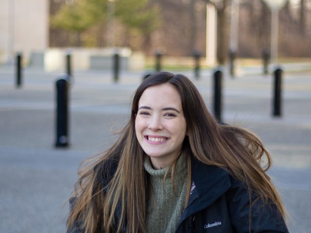 Sam smiling for a portrait outside Engineering Hall.