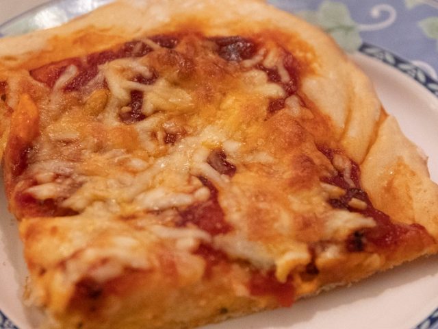 A Sicilian slice of pizza on a plate.