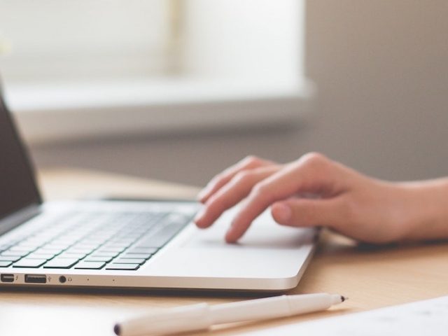 Stock image of woman hand working on a laptop.