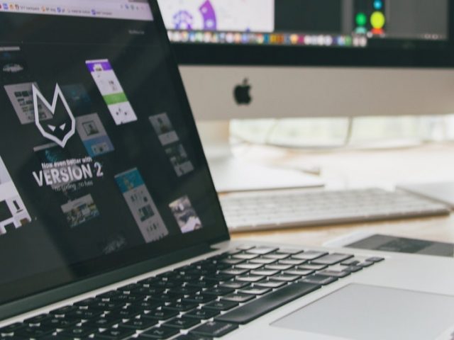 Stock image of a laptop at a home work station.