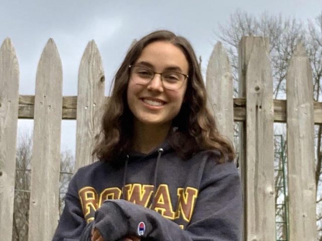 Hannah smiles, wearing a gray Rowan sweatshirt.