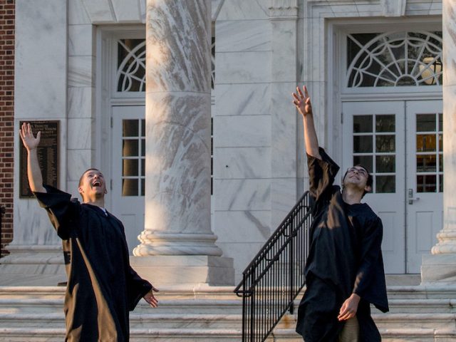 four grads toss their hat.